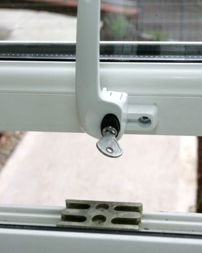 Close up of white window handle and lock